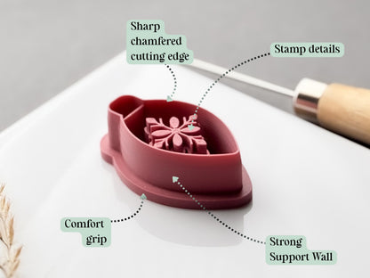 Feature graphic showing the floral Christmas bauble clay cutter, with labels highlighting the sharp chamfered cutting edge, floral stamp details, comfortable grip and strong support wall.