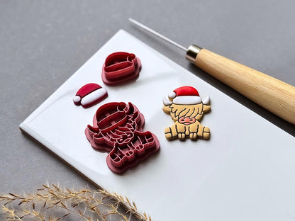 Highland cow Christmas polymer clay cutter set displayed beside the matching finished clay Highland cow wearing a Santa hat, with a separate Santa hat cutter and finished hat shown alongside.
