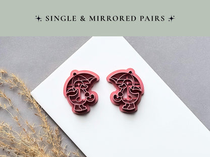 Single and mirrored umbrella character polymer clay cutters displayed side by side, featuring a character holding a curved umbrella with detailed internal stamp lines on a white tile.
