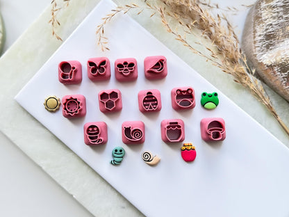 Mini spring and summer wildlife themed polymer clay stud earring cutters. The designs shown are butterfly, bee, bird, sun, honey comb, ladybird, frog, caterpillar, snail, jar and mushroom shapes.