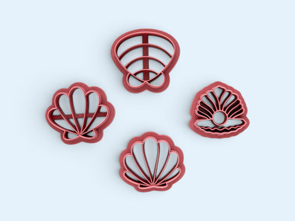 Four pink plastic seashell-shaped polymer clay cutters arranged on a light blue background.