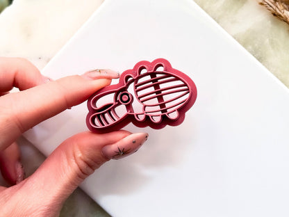 Close up to abstract stag beetle clay cutter showing embossing stamp lines and the support structure to give the cutter strength. 